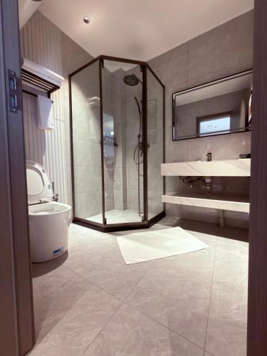 a bathroom with a shower and a toilet and a sink at Hotel Eden24 Novembre in Kinshasa