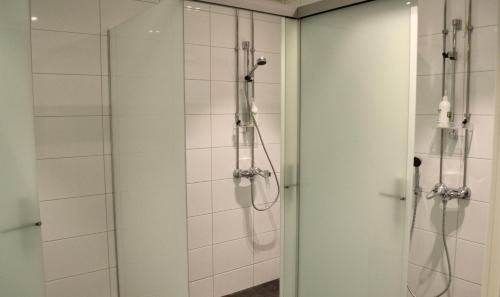 a shower in a bathroom with a glass door at The Yard Hostel in Helsinki