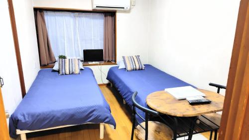 a small room with two beds and a table at Kokusaigakusya Ozukikaikan - Vacation STAY 18798 in Hadano