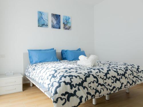 a bedroom with a black and white bed with blue pillows at Moderno Bilocale Con Parcheggio Privato in Piacenza