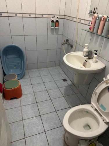 a bathroom with a toilet and a sink at Lukang Hongyu Hostel in Lukang