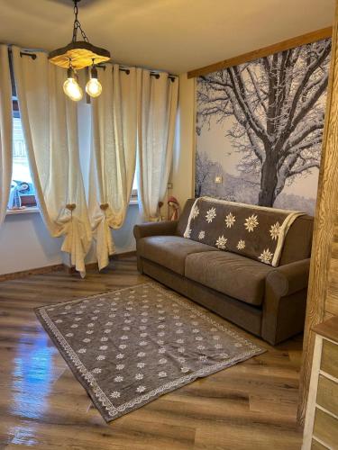 a living room with a couch and a rug at Rifugio nella neve in Sestriere