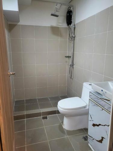 a bathroom with a toilet and a phone on the wall at matthew's cozzy staycation suit in Sampong