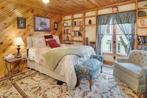 a bedroom with a bed and a chair and a window at Glass Magnolia Bed & Breakfast in Interlaken