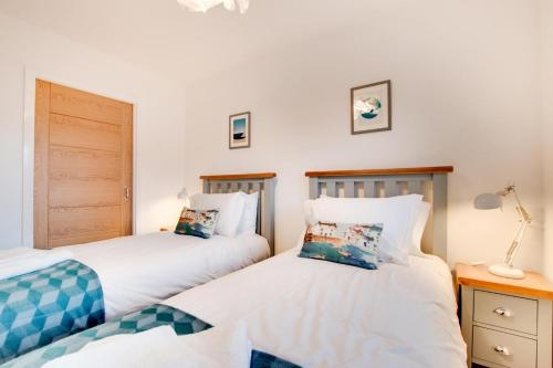 two twin beds in a room with white walls at 2 Bed in Westward Ho oc-idleho in Northam