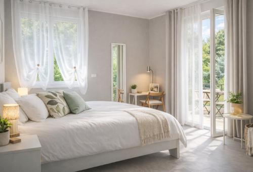 a white bedroom with a large bed and windows at Casa Rosetta - Relax in Centro - Parcheggio Privato, Mare a 2 Passi in Bordighera