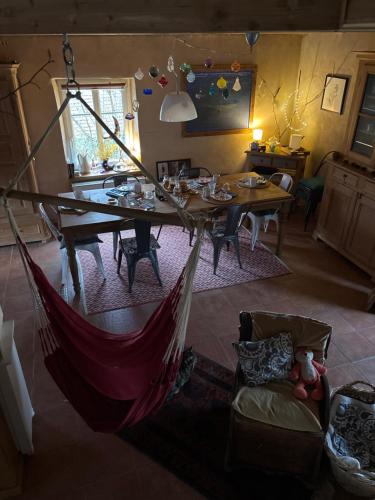 a hammock in a living room with a table at Maison d'hôtes des Mondfänger in Meisenthal