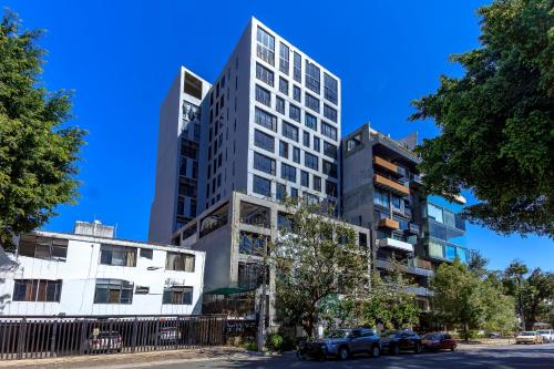 a tall building with cars parked in front of it at Atena Urban Living in Guadalajara