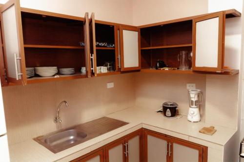 a kitchen with wooden cabinets and a counter top at Departamento 1 centro de la ciudad in Santo Domingo de los Colorados
