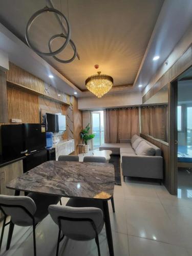 a living room with a table and a couch at matthew's cozzy staycation suit in Sampong
