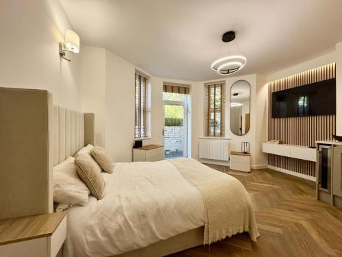 a bedroom with a large bed and a television at West Cliff Studio - Private Garden mins from Beach in Bournemouth