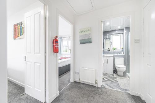 a white bathroom with a toilet and a sink at Prime Commuter Executive Apartment Dunfermline in Dunfermline