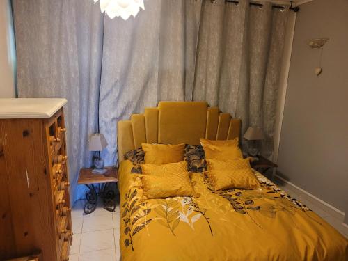 ein gelbes Bett mit gelben Kissen in einem Schlafzimmer in der Unterkunft Mas Cornille in Fontvieille