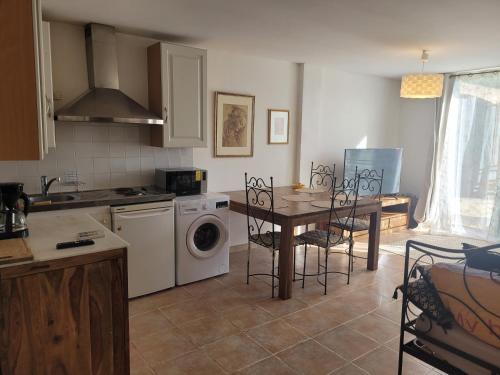 eine Küche mit Tisch, Herd und Spüle in der Unterkunft Mas Cornille in Fontvieille