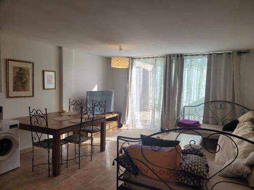 ein Wohnzimmer mit einem Tisch und ein Esszimmer in der Unterkunft Mas Cornille in Fontvieille