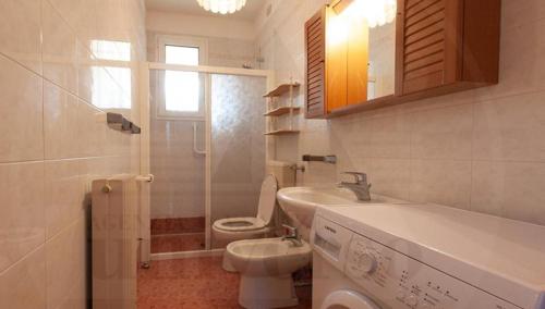 a white bathroom with a toilet and a sink at RESIDENCE MARCO POLO in Eraclea Mare