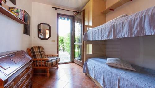 a bedroom with a bunk bed and a chair at RESIDENCE MARCO POLO in Eraclea Mare