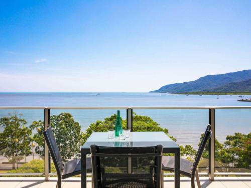 a table and chairs on a balcony overlooking the ocean at Mantra Trilogy in Cairns