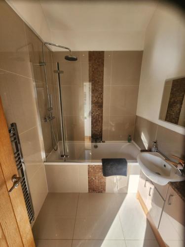 a bathroom with a shower and a sink and a tub at THE BOATHOUSE. The gateway to the Jurassic Coast in Hamworthy