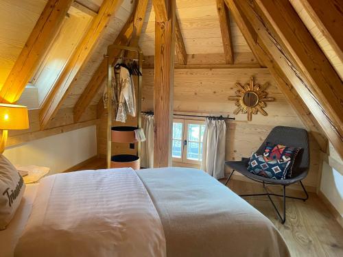 a bedroom with a large bed and a chair at Black Cockatoo Lodge close to Bern and Thun in Oberdiessbach