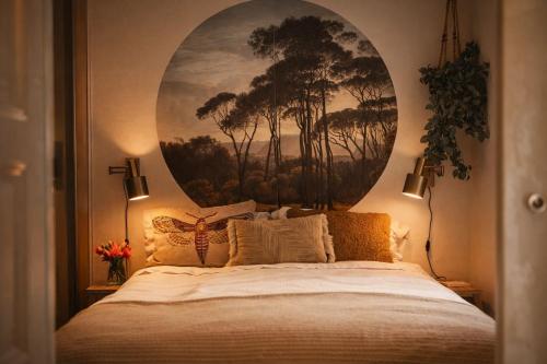 a bedroom with a bed with a painting on the wall at Natuurhuisje met omheinde tuin hond welkom stijlvol ingericht StayatSas Julia in Epe
