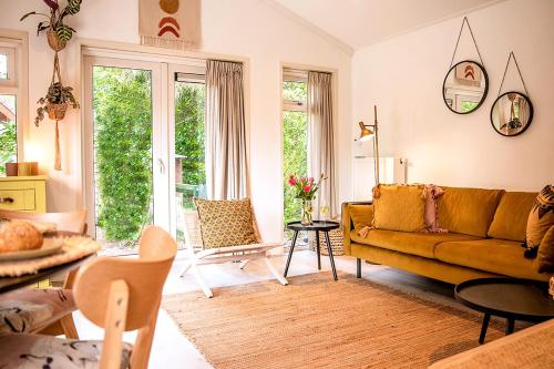 a living room with a couch and a table at Natuurhuisje met omheinde tuin hond welkom stijlvol ingericht StayatSas Julia in Epe