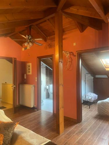 a living room with orange walls and a ceiling fan at Chaido's attic in Larisa