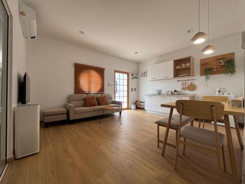 a living room with a couch and a table at Muji house Chiangmai 01 in Chiang Mai