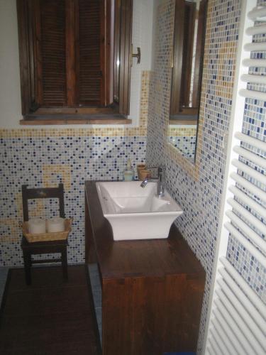 a bathroom with a white sink and a chair at Casa Vacanza La Valle in Urbino