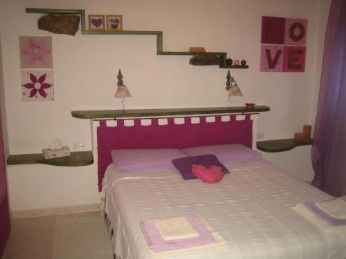a bedroom with a bed with a purple head board at Casa Vacanza La Valle in Urbino