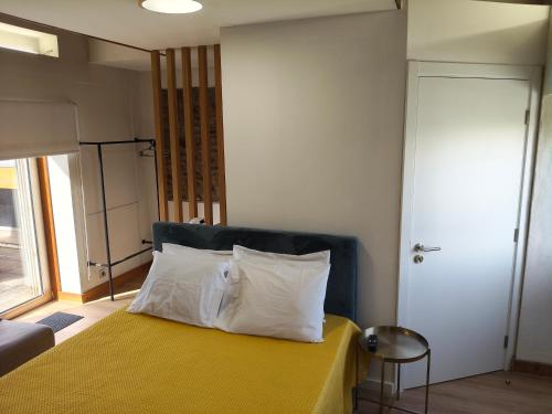 a bedroom with a yellow bed with white pillows at Casa da Capela in Folgosa