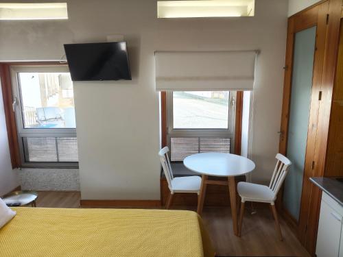 a room with a table and two chairs and a window at Casa da Capela in Folgosa