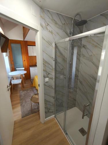 a glass shower in a room with a table at Casa da Capela in Folgosa
