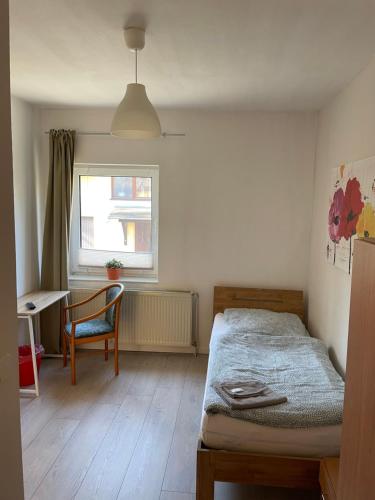 a bedroom with a bed and a chair and a window at Pension am Markt Luckenwalde in Luckenwalde