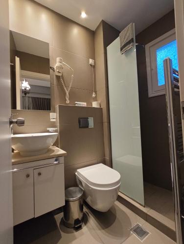een badkamer met een wit toilet en een wastafel bij Hotel Galaxidi in Galaxidhion