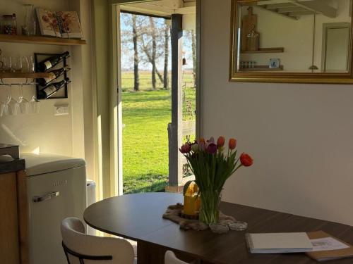 a kitchen with a table with a vase of flowers on it at 'T Dijkhuisje - Driehuizen in Driehuizen