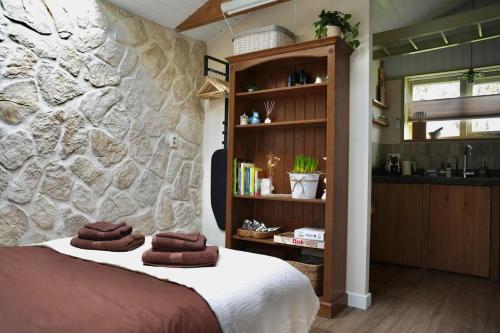a bedroom with a stone wall and a bed at 'T Dijkhuisje - Driehuizen in Driehuizen