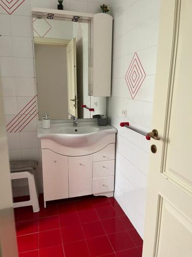 a bathroom with a sink and a mirror and red floor at Casa Petralia in Petralia Sottana