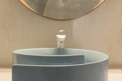 a round blue sink with a mirror on the wall at Elite Luxury Suites in Oia