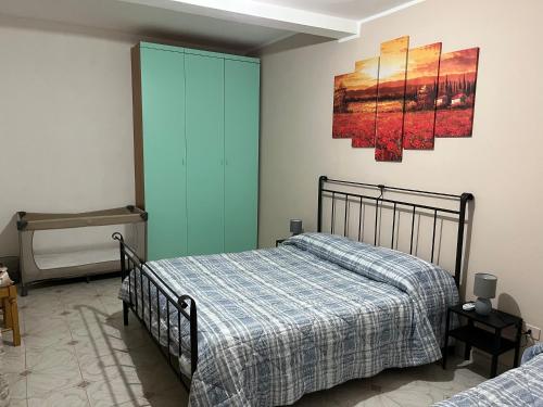 a bedroom with two beds and a painting on the wall at Casa Petralia in Petralia Sottana
