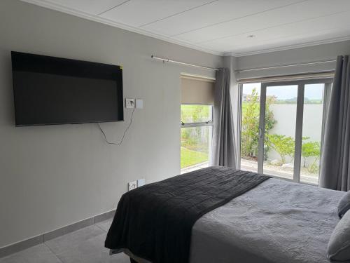 a bedroom with a bed and a flat screen tv at 22 Mountain View in Herolds Bay
