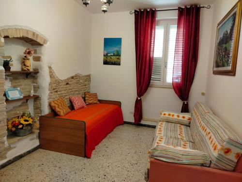 a bedroom with a bed and a couch and a window at L'antica Terrazzella in Vasto