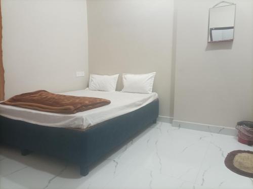a bed with a blanket on it in a room at आदिनाथ गेस्ट हाउस in Ujjain