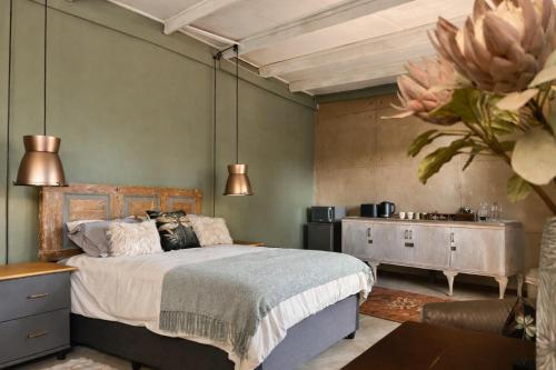 a bedroom with a bed and a dresser and a table at Gallo Vista B & B in Gillitts-Emberton