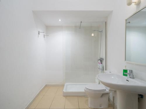 a white bathroom with a toilet and a sink at Celia House in Las Palmas de Gran Canaria