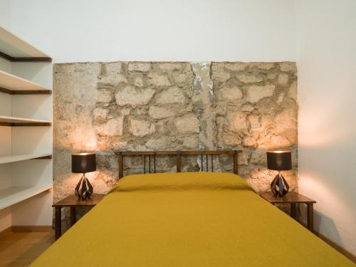 a bedroom with a yellow bed with two lamps at Celia House in Las Palmas de Gran Canaria
