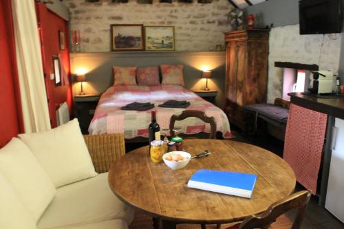 a bedroom with a bed and a table with a bed at Gîte ABMA in Clugnat