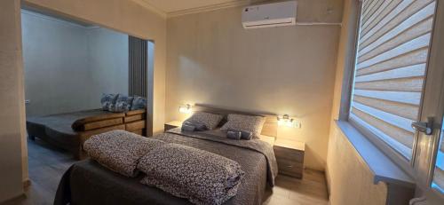 a bedroom with two beds and a window at Еви 1 in Gabrovo