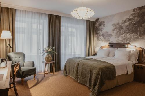 a hotel room with a bed and a chair at Home Hotel Baltzar in Malmö