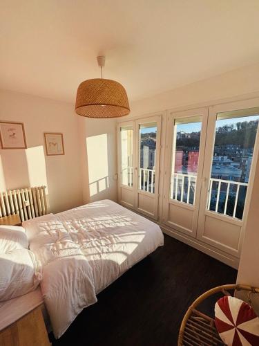 a bedroom with a bed and windows with a view at Le Gouvernail in Le Tréport